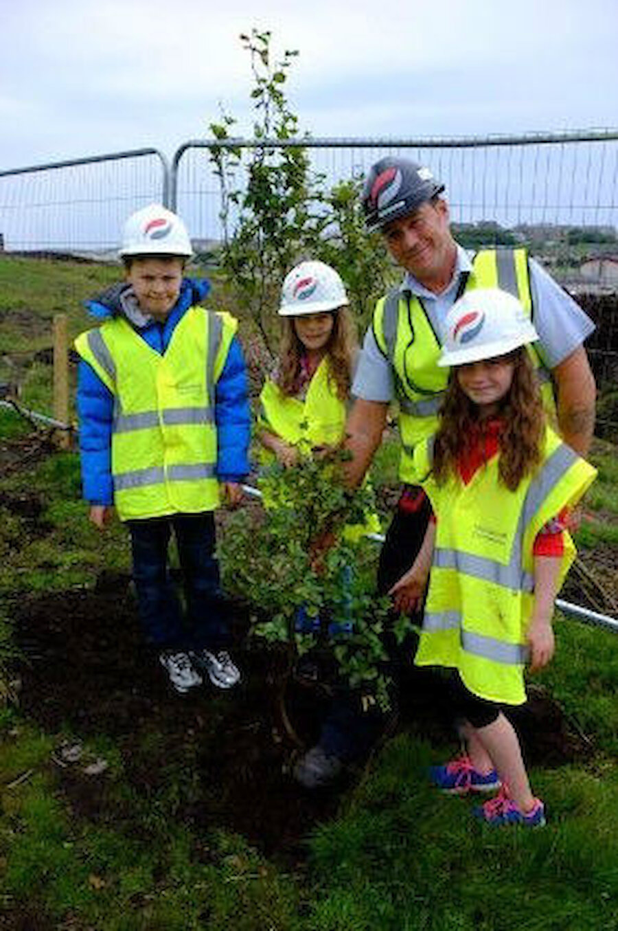 Morrison’s Site Manager Callum Cassidy planting trees with Bell’s Brae Primary School pupils (left to right) Nathan Freidlander, Emily Gifford and Ruth Anderson. (Courtesy Shetland Islands Council)