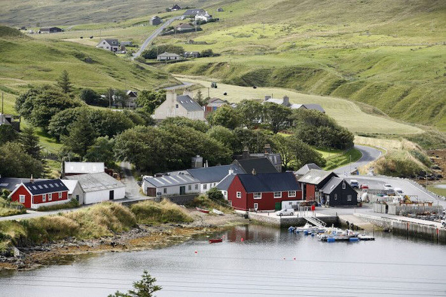 The village of Voe: the bakery is situated just behind the large red building, which is now a camping bod but once housed weavers and knitters (Courtesy VisitScotland)