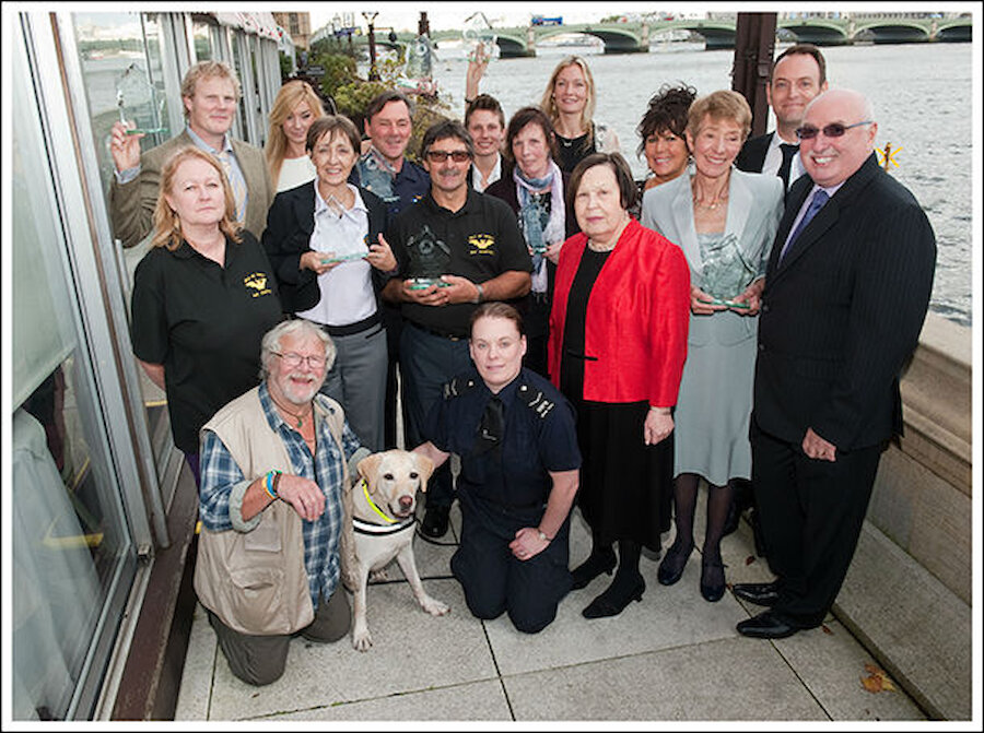 The class of 2014 IFAW Animal Action Award winners, with hosts Baroness Gale (in red) and Bill Oddie (kneeling, left), and IFAW’s Azzedine Downes (far right) and UK Director Philip Mansbridge (second from right). Jan Bevington is in the centre of the group, wearing a scarf. (Courtesy IFAW)