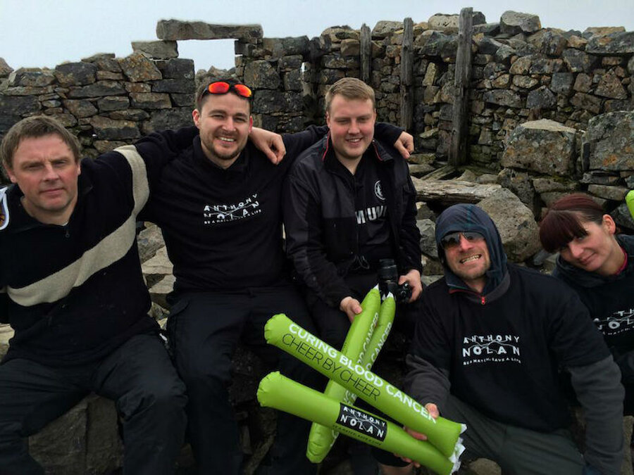 Craig (second from left) and his supporters rest at the summit of Ben Nevis on one of their seven climbs. (Courtesy Craig Smaaskjaer).
