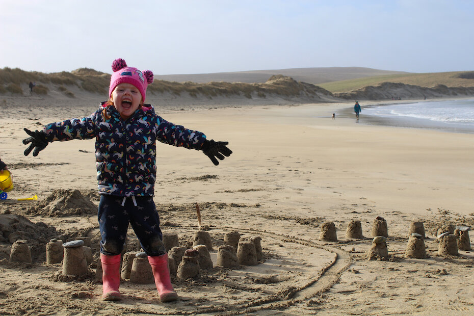Amelia celebrates some impressive sand castle building at Spiggie. | Mic Hall
