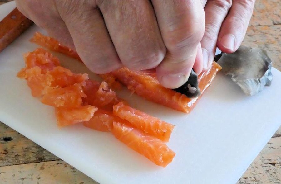 Cutting the salmon with a piece of flint. | Alastair Hamilton