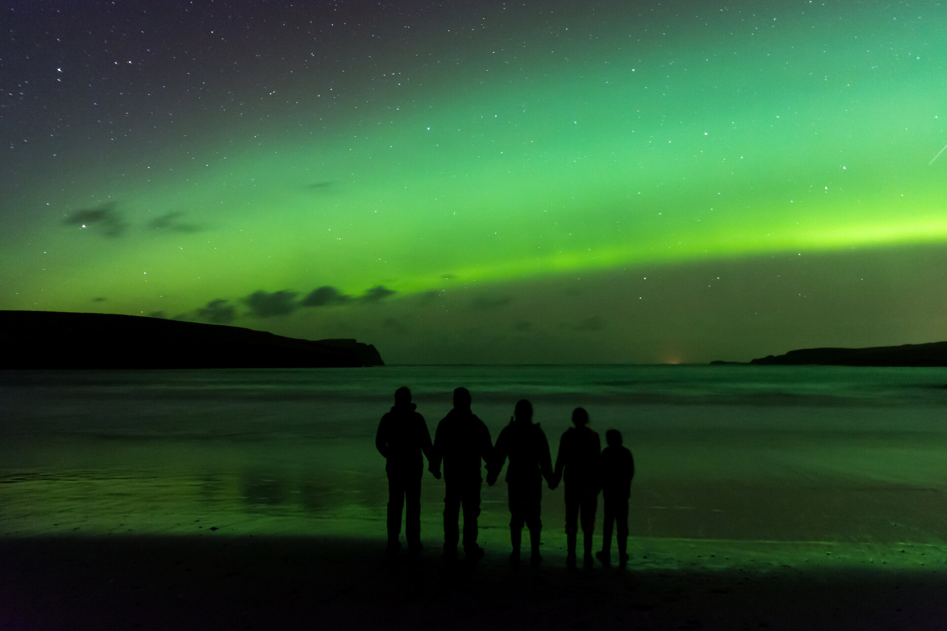 A family enjoys the opportunity to witness the northern lights in Sheltand.