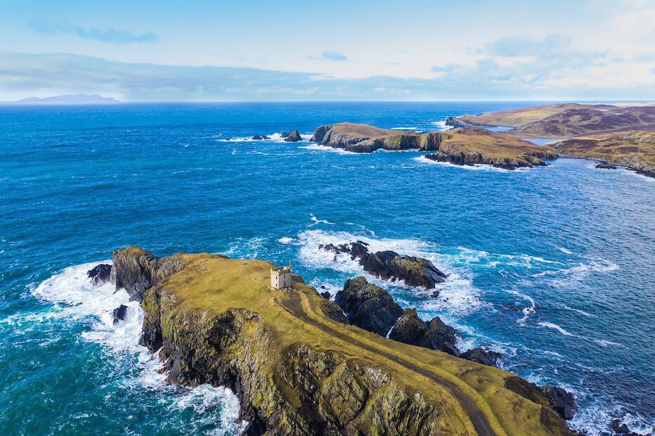 The Vaila watchtower surrounded by the deep blue sea. | @shetland_by_drone