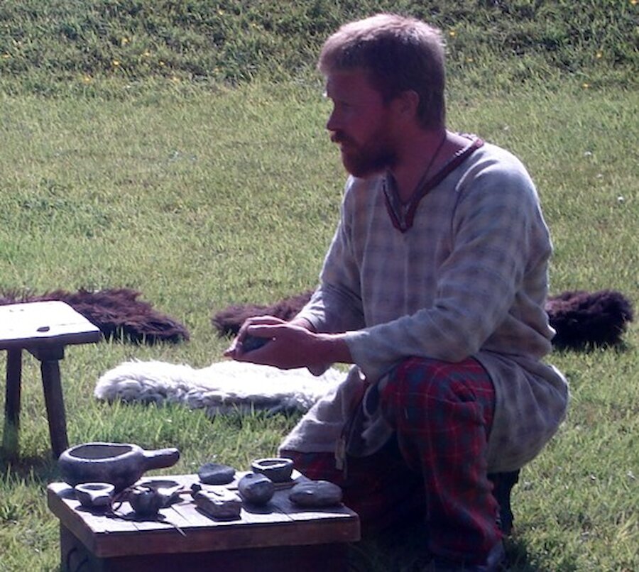 A living history presenter demonstrates how soapstone was carved by Vikings in Shetland.