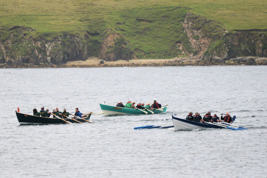 Boats from Lerwick, Trondra and Bigton race for the line in the Shetland Boat Week 2019 rowing race held at Scalloway (Courtesy Alastair Hamilton)
