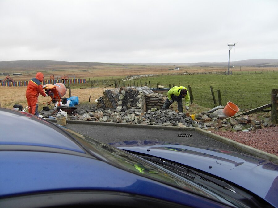 Stonemasons at work on the Unst geowall.