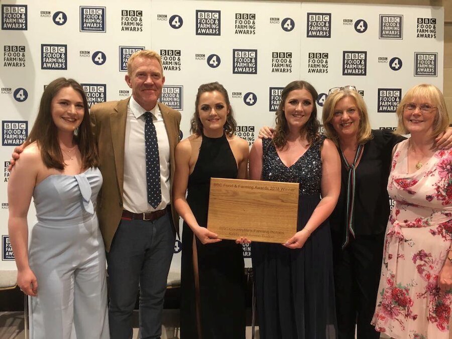 Kirsty and Aimee receive the award from Adam Henson; third sister Hannah is on the left and mum Helen is on the right (Courtesy BBC)