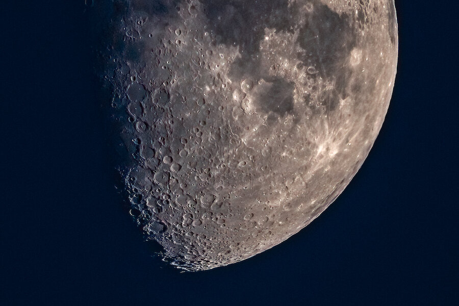 Look out for craters and mountains on the lunar surface.