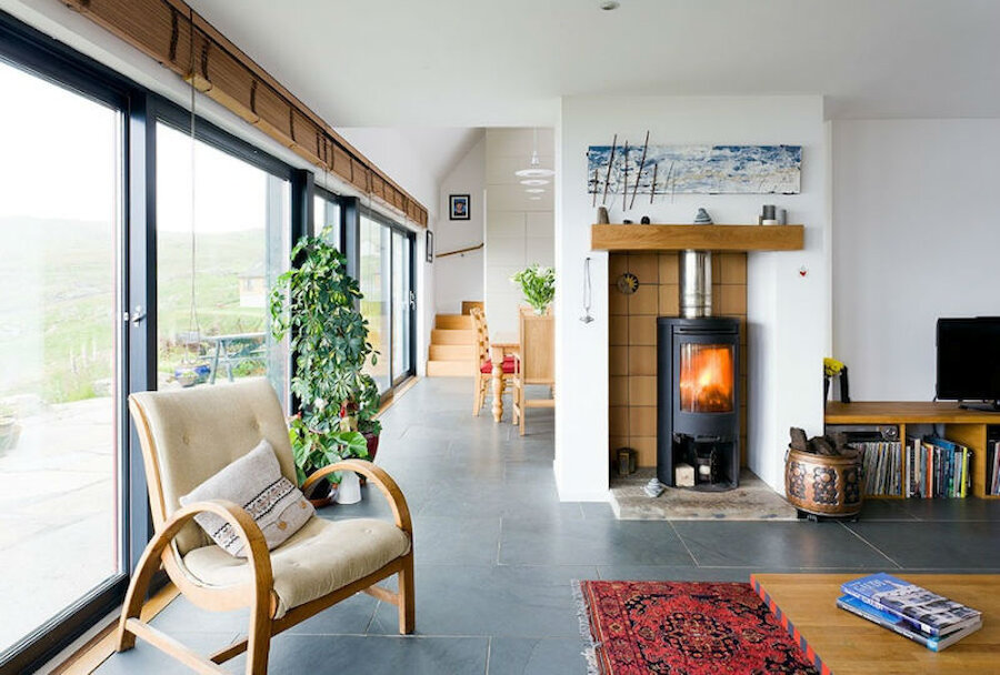 A glazed wall and slate flooring makes the very best of solar energy at Grunnabreck (Courtesy Malcolmson Architects)