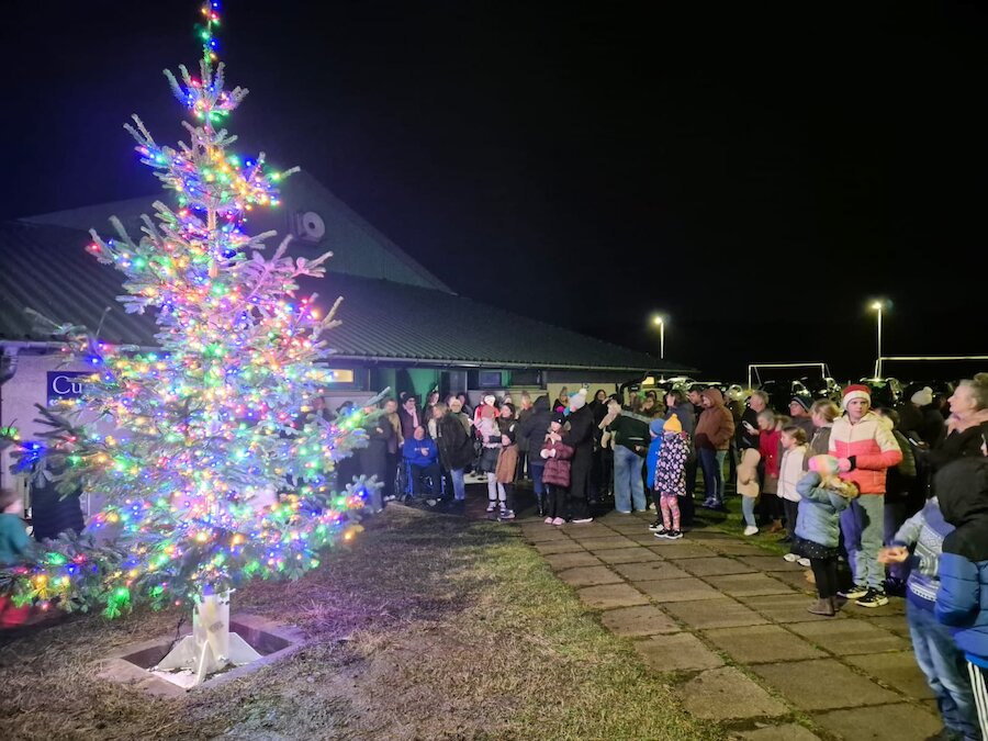 A large crowd celebrating with carol singing, mince pies, hot chocolate and mulled wine at the Cunningsburgh Christmas Tree switch-on in 2025