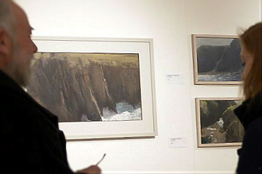 Two visitors pause by Chris Rigby's cliff scenes.