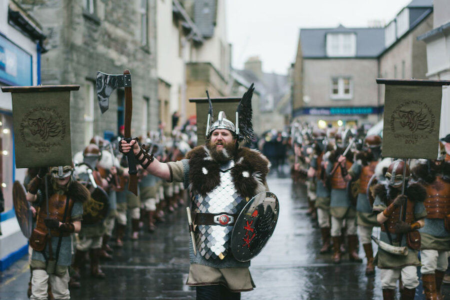 The Guizer Jarl and his squad march along Commercial Street towards the Market Cross (Courtesy Alex Mazurov)