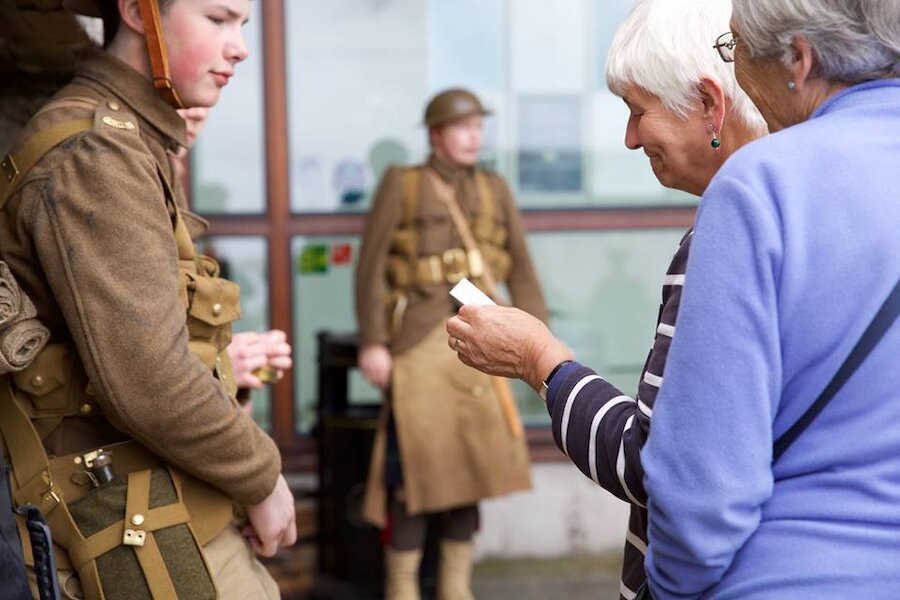 A passer-by receives a card that bears the name of the soldier that the man represents (Courtesy Paul Riddell)